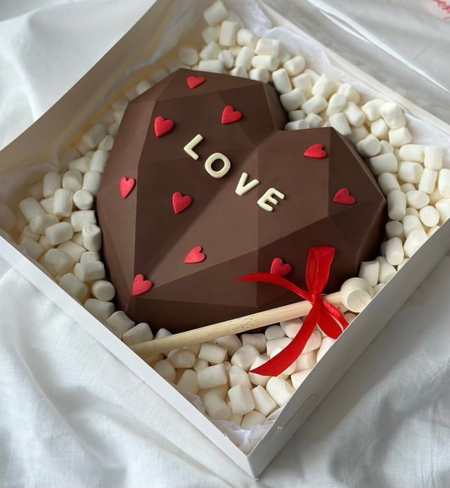 Breakable chocolate heart with strawberries inside
